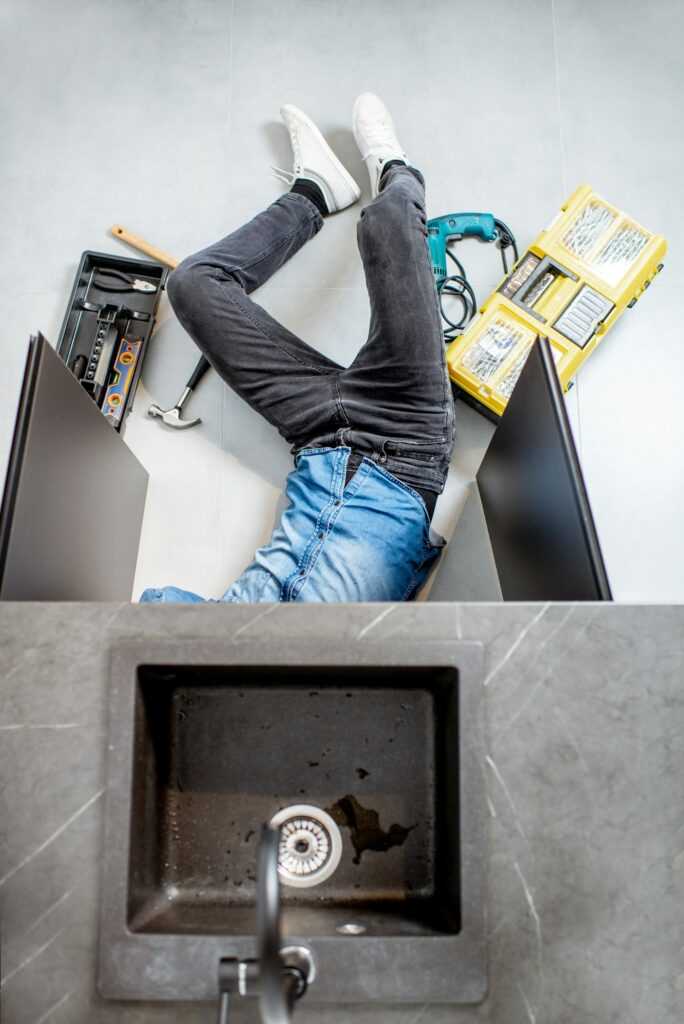 Man repairing kitchen plumbing